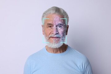Facial recognition system. Scanning man's face for authentication against white background
