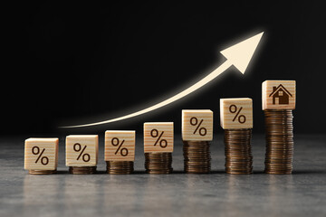 Increase in real estate value. Coins, cubes with percent signs and house icon on table. Growing...