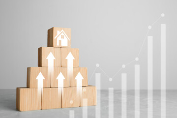 Increase in real estate value. Wooden cubes with arrows and house icon on table. Growing price...