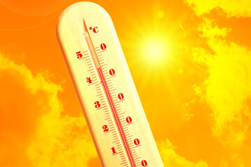Extremely high temperature on thermometer against orange sky on sunny day. Severely hot summer...