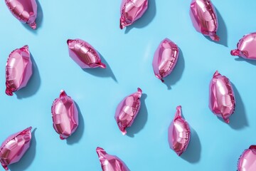 Creative arrangement of pink foil balloons on blue background for party decoration
