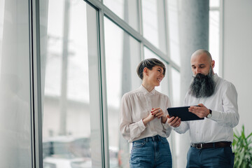 Business colleagues using digital tablet in modern office