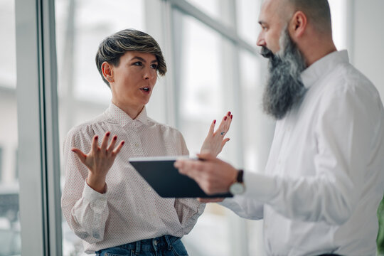 Businesswoman explaining strategy using tablet to senior manager in office