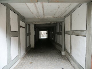 Long hallway with white walls and wooden beams