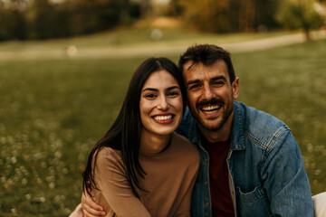 Happy couple smiling and embracing in a park