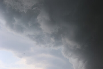 Dark storm clouds forming in the sky before a thunderstorm. Dramatic, moody atmosphere symbolizing...
