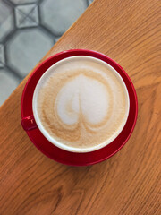 Cappuccino with Heart Latte Art in Red Cup on Table