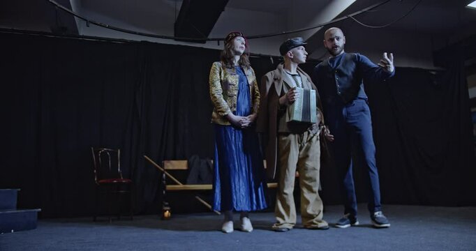 Young actors rehearse a play on stage. A director guides them, providing instructions and feedback for improvement.