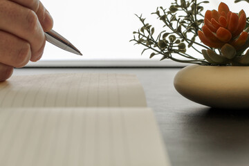 Close-Up of Pen Tip Hovering Above Blank Notepad Page