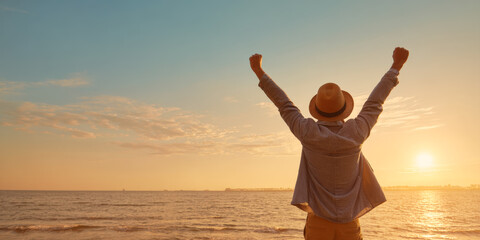 A powerful image of a man raising his arms in triumph against a vibrant sunset over the ocean, symbolizing success, freedom, and the joy of achievement in a beautiful, natural setting