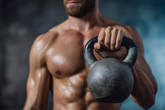Muscular man lifting a heavy kettlebell showcasing strength and fitness in a gym environment