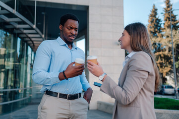 Business partners discussing during coffee break near office building
