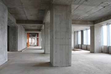 Under Construction: Interior View of a Business Center Showcasing Concrete Pillars and Grey Walls