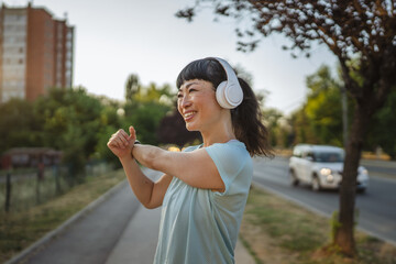 Japanese woman in a sportswear stretching on the street before jogging