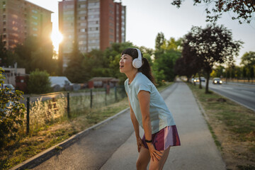 Japanese woman in a sportswear stretching on the street before jogging
