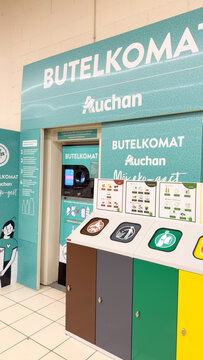 Warsaw, Poland - June 28, 2025: Auchan Butelkomat recycling station with colorful waste sorting bins