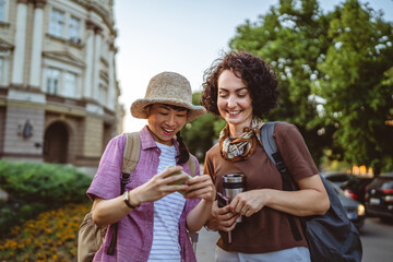two women use mobile phone for directions walk and touring city