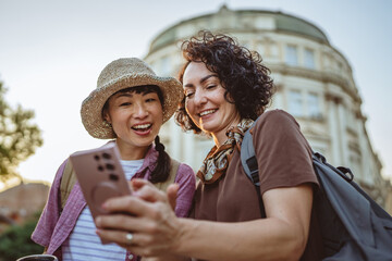 two women use mobile phone for directions walk and touring city