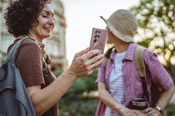 two women use mobile phone for directions walk and touring city