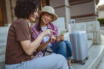 female tourist use mobile phone for directions while sit on staircase