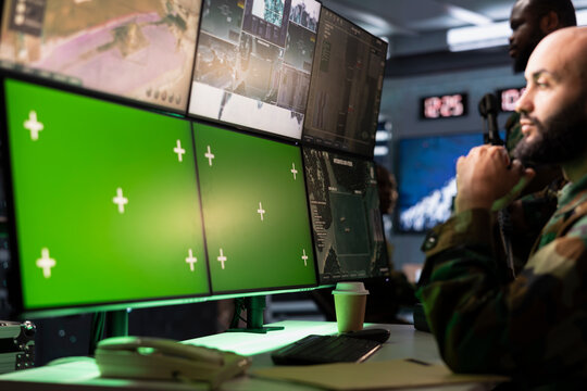 Air defense operative using radar on green screen equipment to detect ballistic missiles. Army soldier scanning rockets approaching borders using chroma key satellite hardware, deploying shields - Powered by Adobe