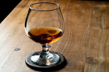glass of brandy on wooden table