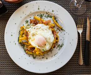 Delicious fried eggs with bacon and potatoes served for breakfast