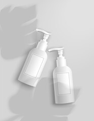 Two cosmetic bottles with palm leaves on a gray background. Packaging template.