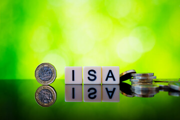Glossy image of ISA letter cubes with upright pound coin and scattered sterling pieces illustrating...