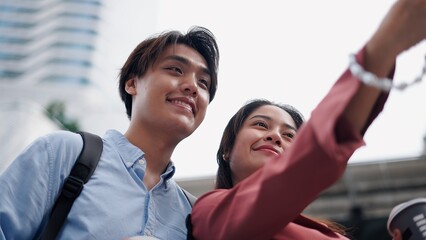 Smiling professionals capturing smartphone selfie during urban workday