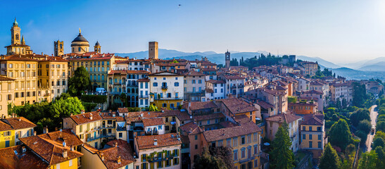 Aerial view of Bergamo&rsquo;s Citt&agrave; Alta in Italy with terracotta rooftops, historic churches, and mountain backdrop
