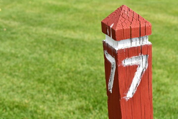 Wooden marker painted in red. Number 7 painted in white.