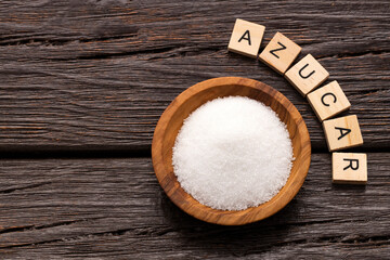 Saccharum officinarum - Fine crystals of refined white sugar on a wooden bowl