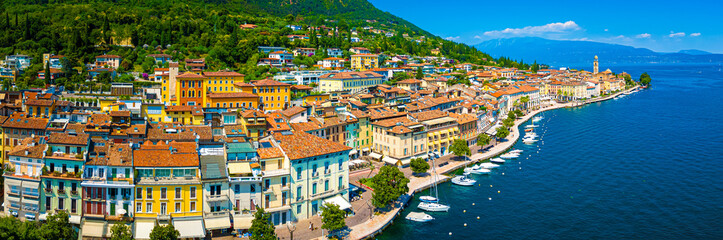 Aerial view of Salo, Italy with terracotta rooftops, lakeside promenade, and boats docked on the...