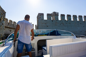 The boat  driver on lake Garda Castle in Sirmione, Italy