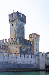 Aerial view of historic Scaliger Castle in Sirmione, Italy, surrounded by mountains