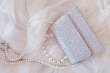 the bride's wedding veil and elegant silver handbag with a chain and pearls