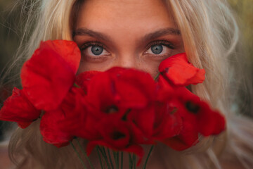 Close-up of female eyes and red poppy flowers