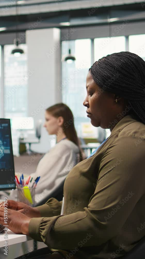 Poster vertical video jolly female programmer at office desk pleased after developing application using mac