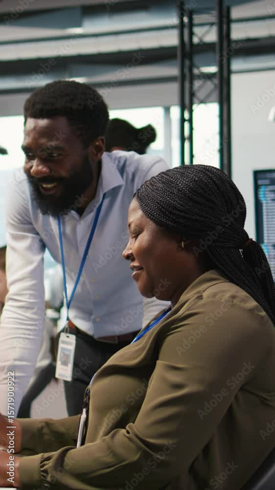 Poster vertical video happy engineers enjoying funny conversation at desk while using ai on computer to opt