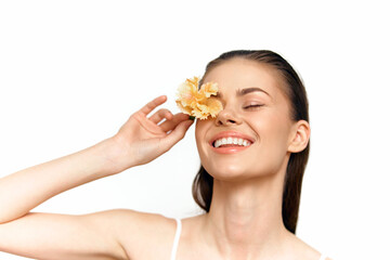 Young woman with a flower, smiling joyfully, on a bright white background, embodying beauty and...
