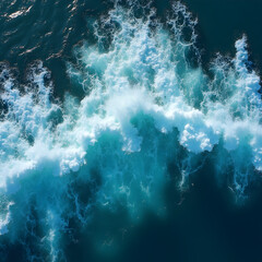 aerial view of sunlit ocean waves crashing wit turquoise water and white foam patterns against deep blue sea