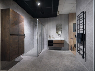 Modern luxury bathroom with glass shower enclosure, floating vanity, and black towel radiator on...