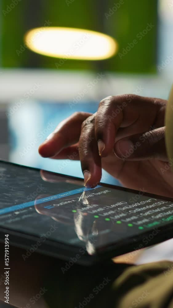 Poster vertical video close up of engineer using tablet to write code, developing machine learning apis. it