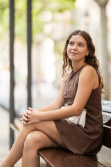 European woman, after an active walk around the city, sat down to rest on a bench