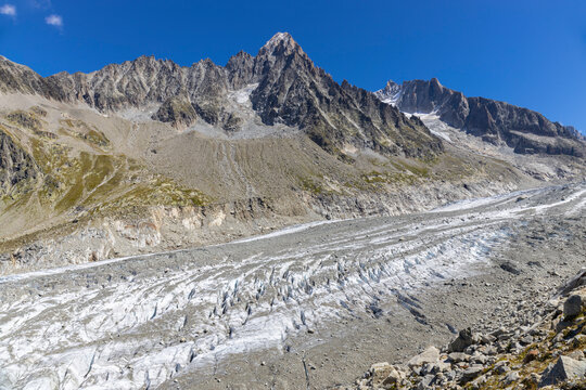 Glacier Argentiere in Chamonix valley, french Alps. Blue ice in a glacier serac and crevasse in the alpine scenic landscape in summer. Aiguille du Chardonnet mountain summit peak above the glacier