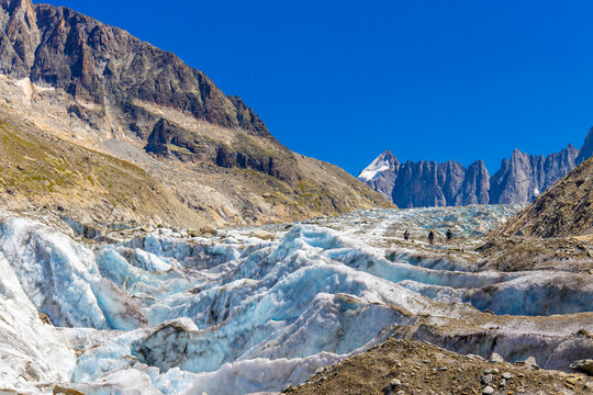 Glacier Argentiere in Chamonix valley, french Alps. Blue ice in a glacier serac and crevasse in the alpine scenic landscape in summer. Aiguille du Chardonnet mountain summit peak above the glacier
