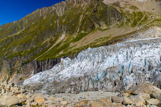 Glacier Argentiere in Chamonix valley, french Alps. Blue ice in a glacier serac and crevasse in the alpine scenic landscape in summer. Aiguille du Chardonnet mountain summit peak above the glacier