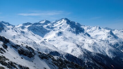 Obraz premium Snowy mountain peaks stretch across the horizon under a blue sky
