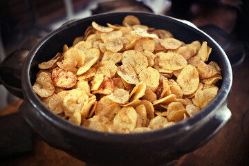 Salty Homemade Kettle Cooked Potato Chips. French fries (chips) in a clay pot. Cooking and kitchen concept.